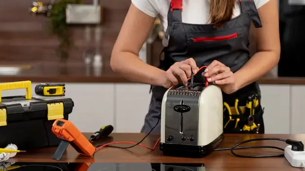 Technician performing Portable Appliance Testing on an electrical device.