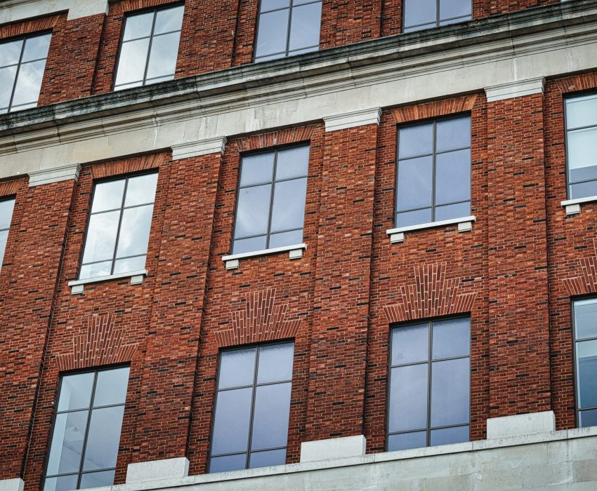Facade,Of,A,Brick,Building,With,Symmetrical,Windows,Reflecting,The